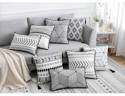 Bohemian style decorative pillowcase in light grey colour on a sofa.