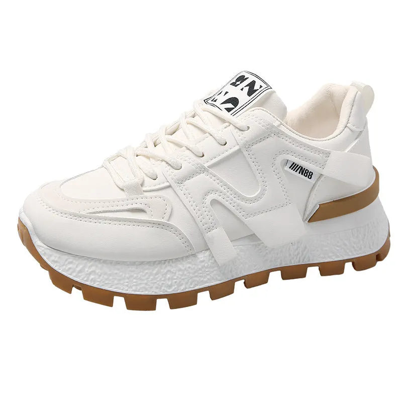 White low-top unisex sneaker with round toe and flat rubber sole on a plain background.
