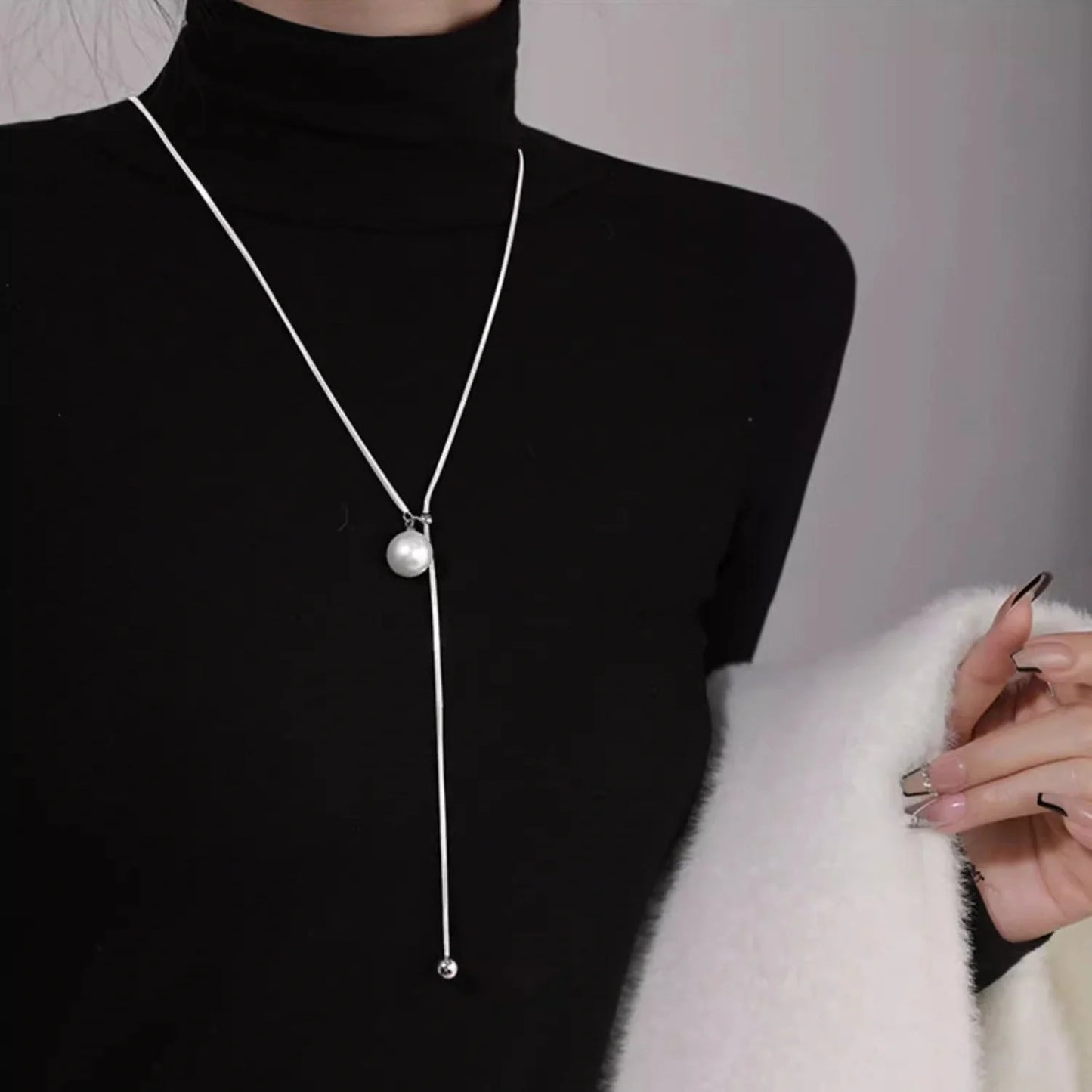 Elegant platinum plated ball necklace with a sleek snake bone chain, perfect for fashionable fall and winter accessorizing