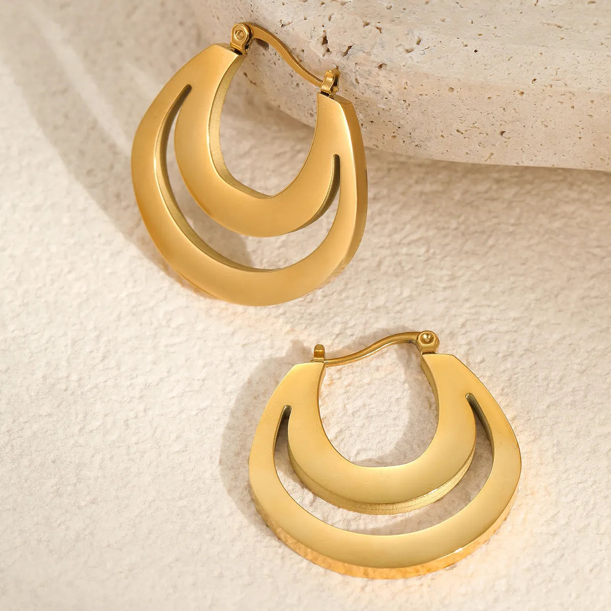 Geometric metallic French earrings in gold or steel colours with round ring design elements