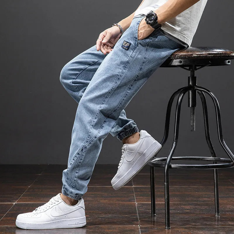 Men's blue cargo jeans with straight-leg fit, micro-elasticity fabric, and cargo pockets on a hanger.
