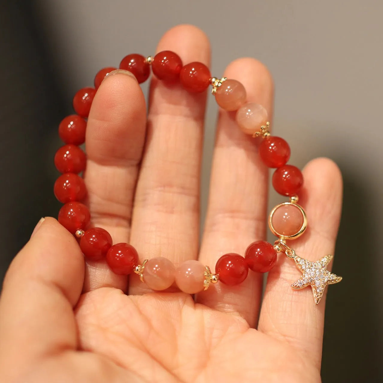 Women's handmade red agate and sunstone bracelet with ethnic charms
