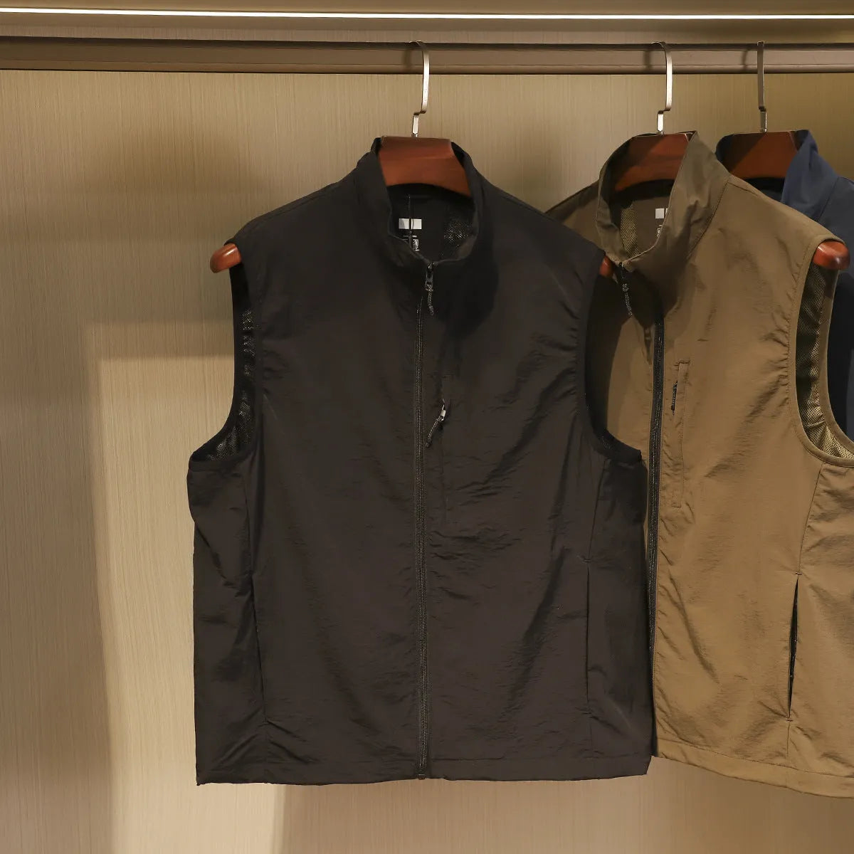 Men's navy blue quick-dry nylon vest cardigan with side pockets on a hanger