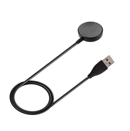 Black plastic USB wireless charging dock for smartwatches on a flat surface.