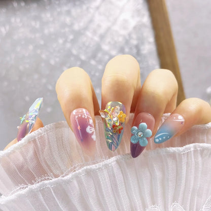 Handmade 3D nail art sculptures showing embossed flowers and butterflies in various sizes on a manicure.
