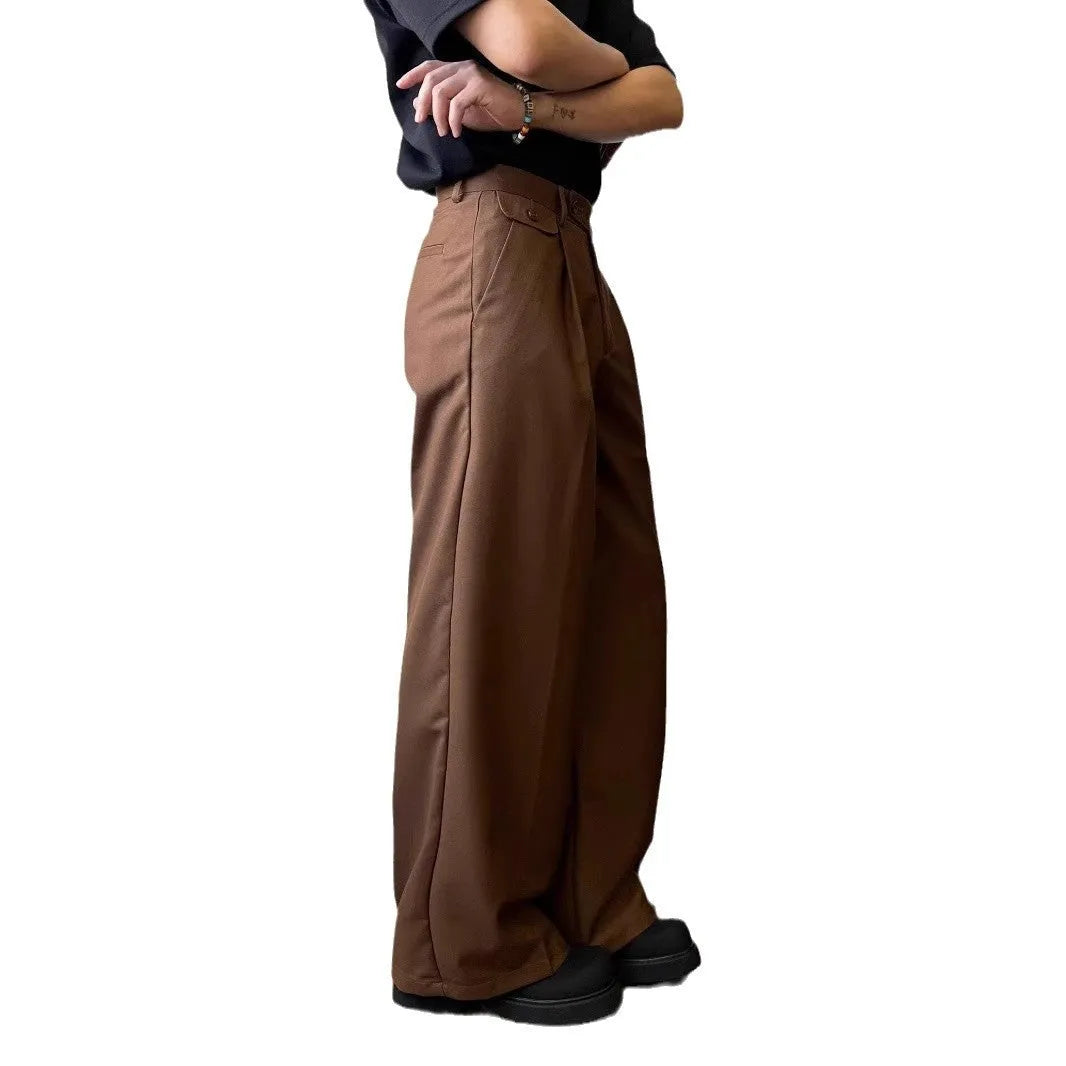 Man wearing solid brown loose straight-leg suit trousers with a casual shirt.