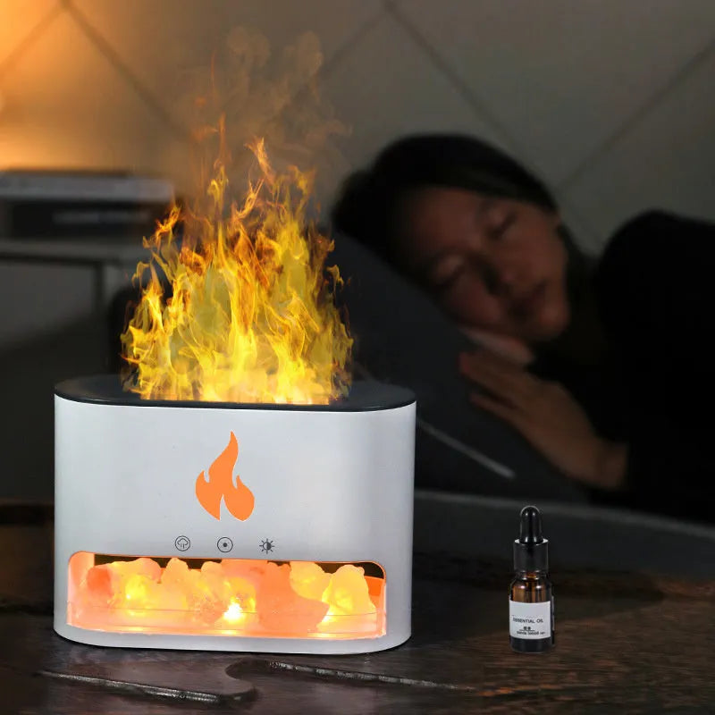 White square flame humidifier with colourful 3D light effect and crystal salt stone on a desk.