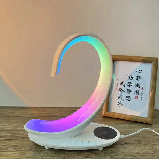 White swan-shaped desktop device with wireless charging surface, Bluetooth speaker, and colourful LED lighting effects