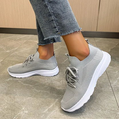 Women's low-top mesh Flyknit tennis shoes in creamy white, with a rubber sole and round toe.