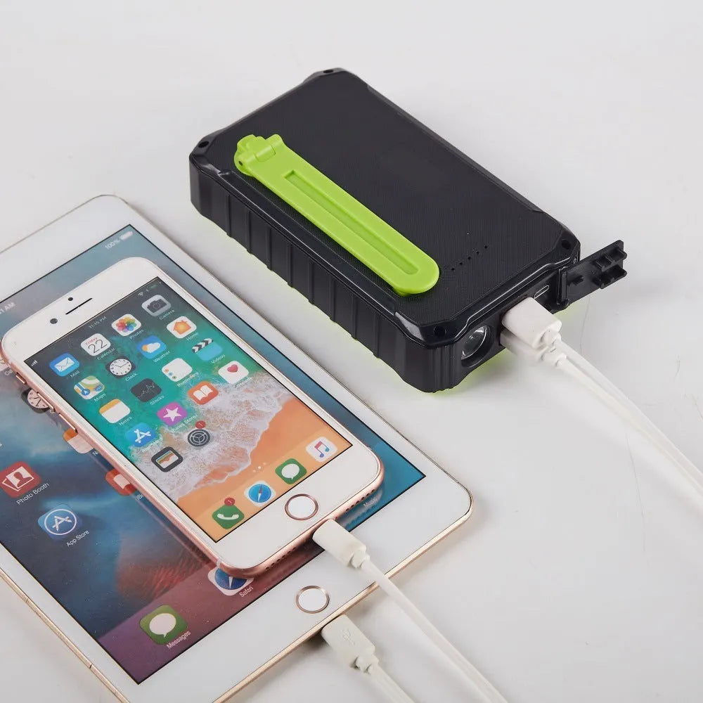 Orange and green hand solar power bank with solar panel, USB ports, and LED light showing 12000mAh capacity