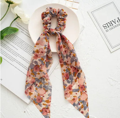Long green ribbon hair tie with large intestine ring and floral pattern, laid flat showing 65cm length