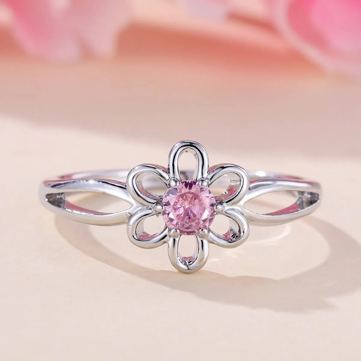 Women's hollow flower design fashion ring in electroplated copper with a platinum pink diamond finish.