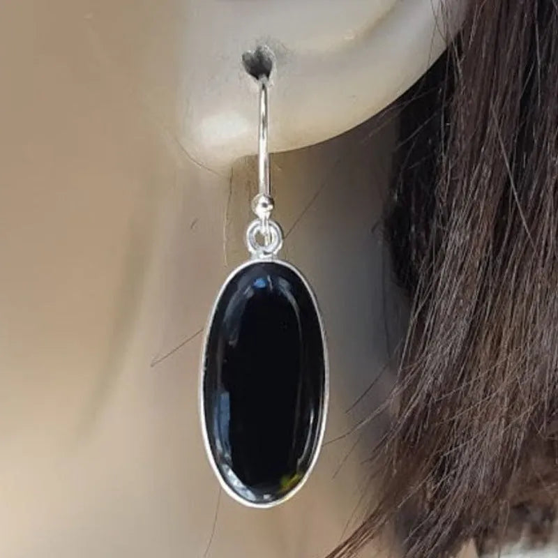 Women's geometric earrings with a black oval agate pendant in a silver electroplated frame.