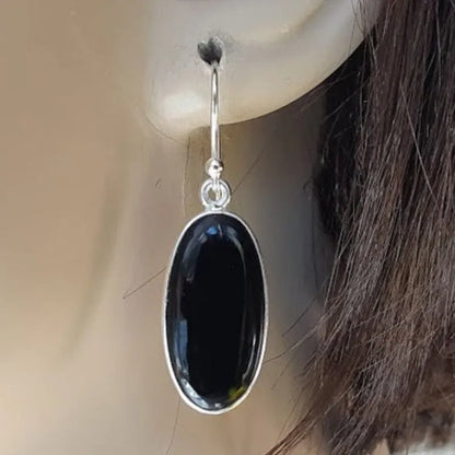 Women's geometric earrings with a black oval agate pendant in a silver electroplated frame.