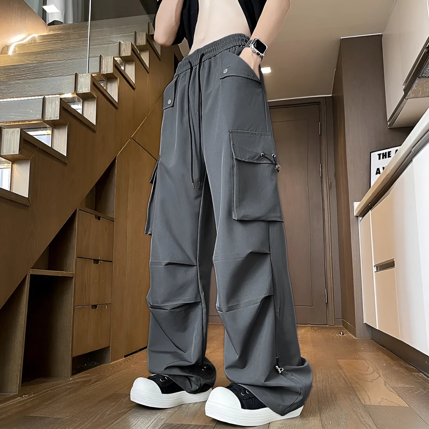 Women's plus-size waterproof trousers in grey, showing straight-leg cut and drawstring waist.