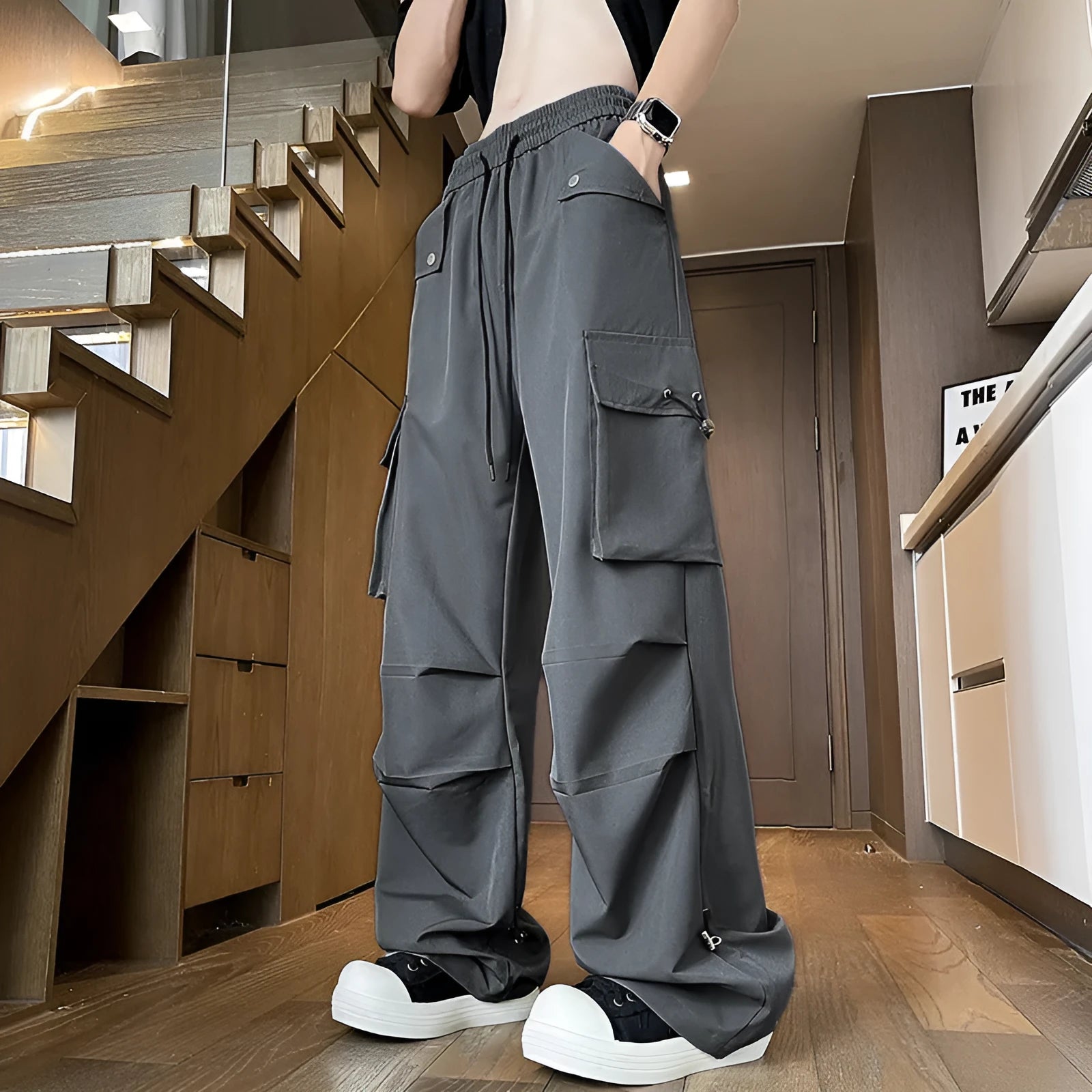 Women's plus-size waterproof trousers in grey, showing straight-leg cut and drawstring waist.