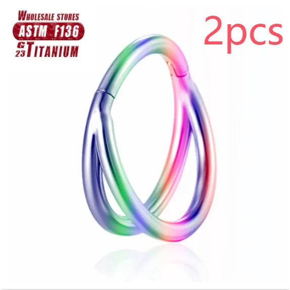 Pair of titanium alloy nose rings on a plain background showing silver, gold, black, and rose gold colour options.