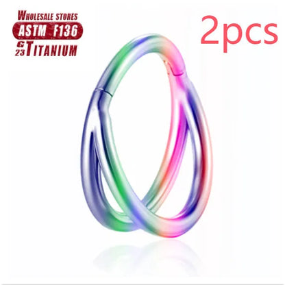Pair of titanium alloy nose rings on a plain background showing silver, gold, black, and rose gold colour options.