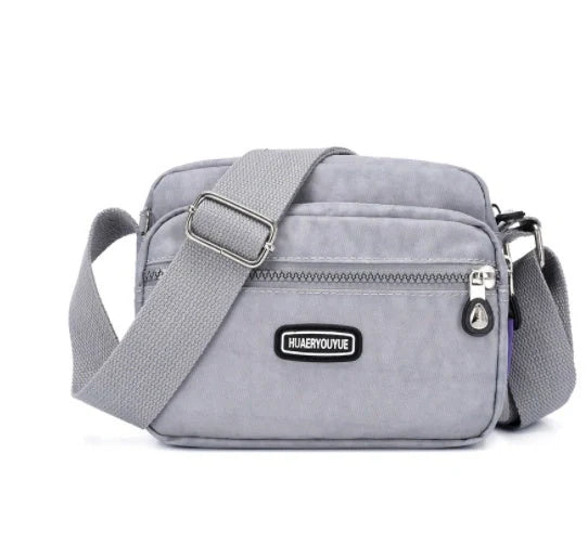 Compact nylon messenger bag in various colors with multiple compartments