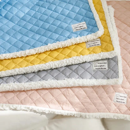 Quilted terry cloth pet blanket for cats in blue, grey, pink, or yellow colour on a pet bed.
