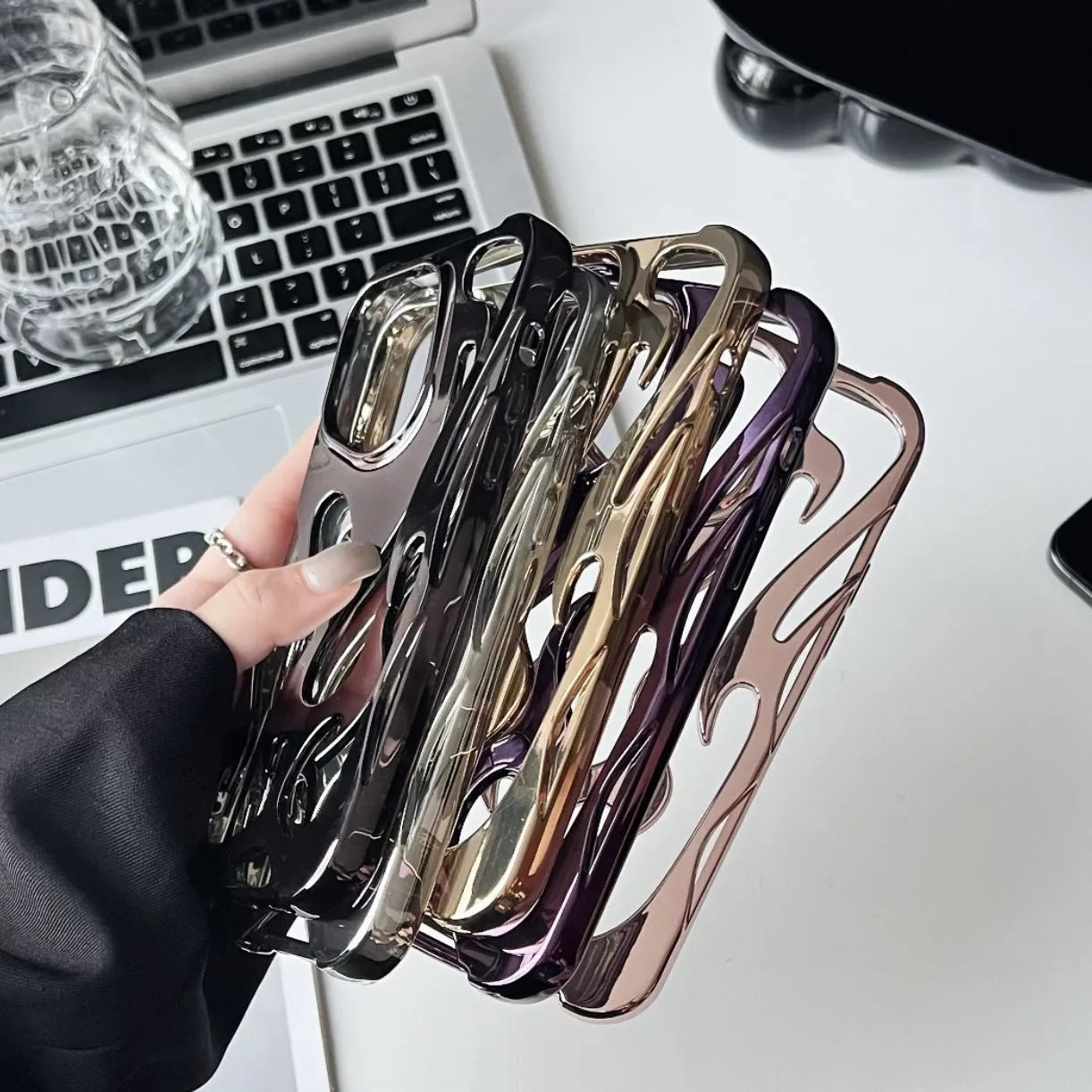 Electroplated hollow flame pattern phone case in silver plated finish on Apple iPhone, showing heat dissipation design and TPU soft shell