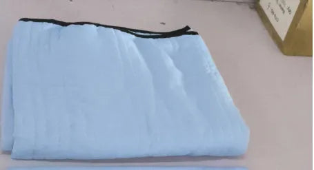 Lightweight plain coloured polyester summer quilt on a bed