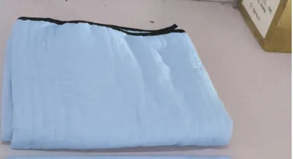 Lightweight plain coloured polyester summer quilt on a bed