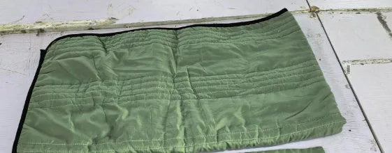 Lightweight plain coloured polyester summer quilt on a bed