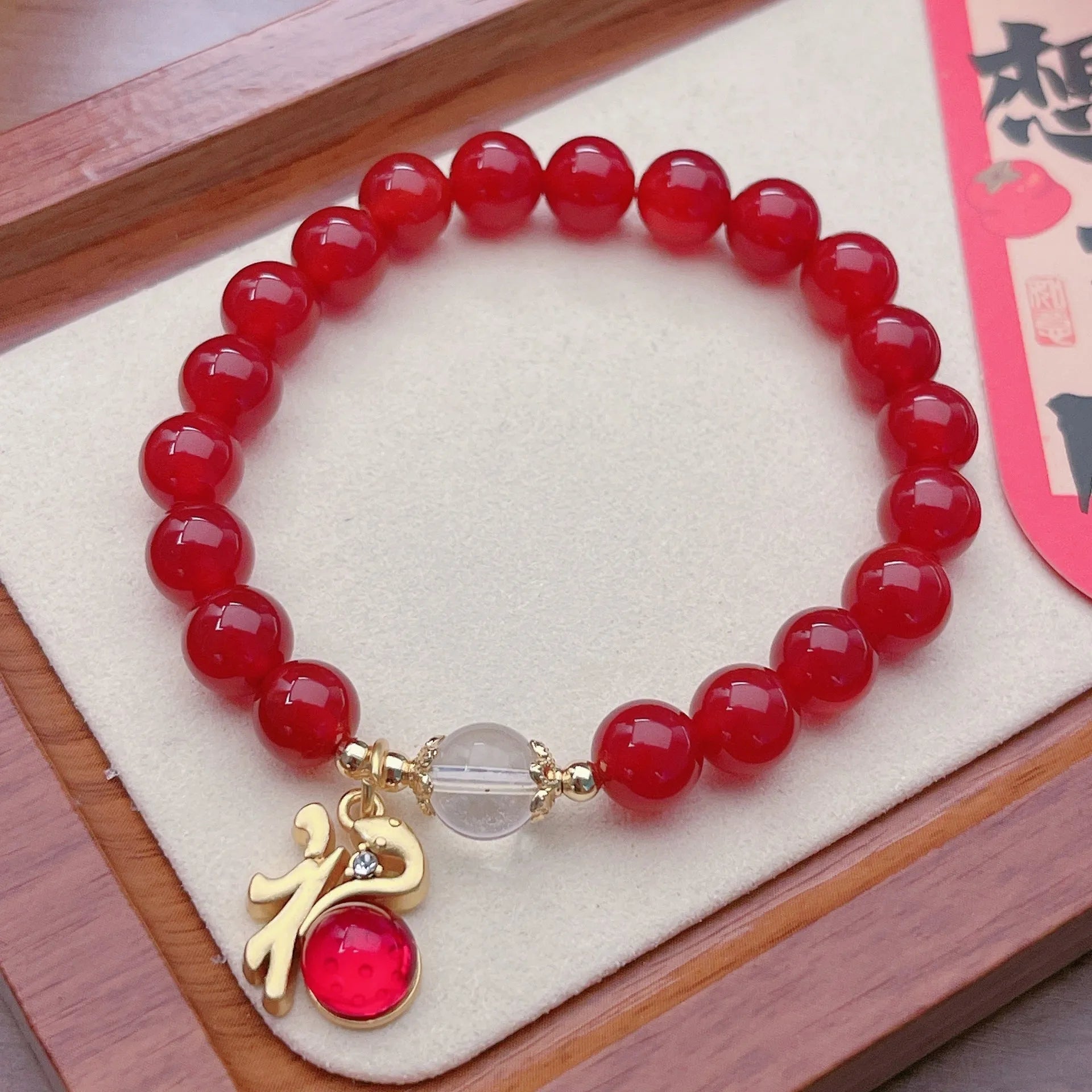 Close-up of a red agate bracelet featuring a detailed dragon design in a Chinese style.