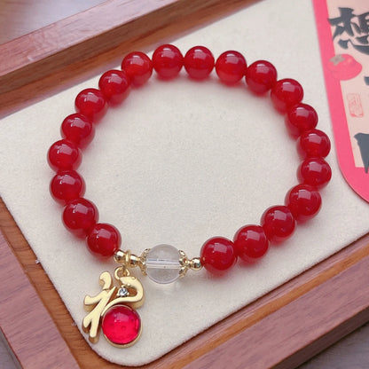 Close-up of a red agate bracelet featuring a detailed dragon design in a Chinese style.