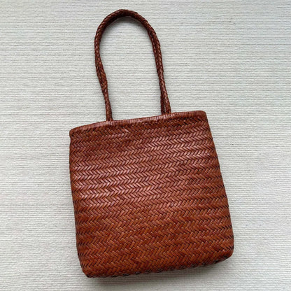 Brown woven cowhide leather tote bag with three-dimensional pocket, shown with dimensions 27cm by 30cm
