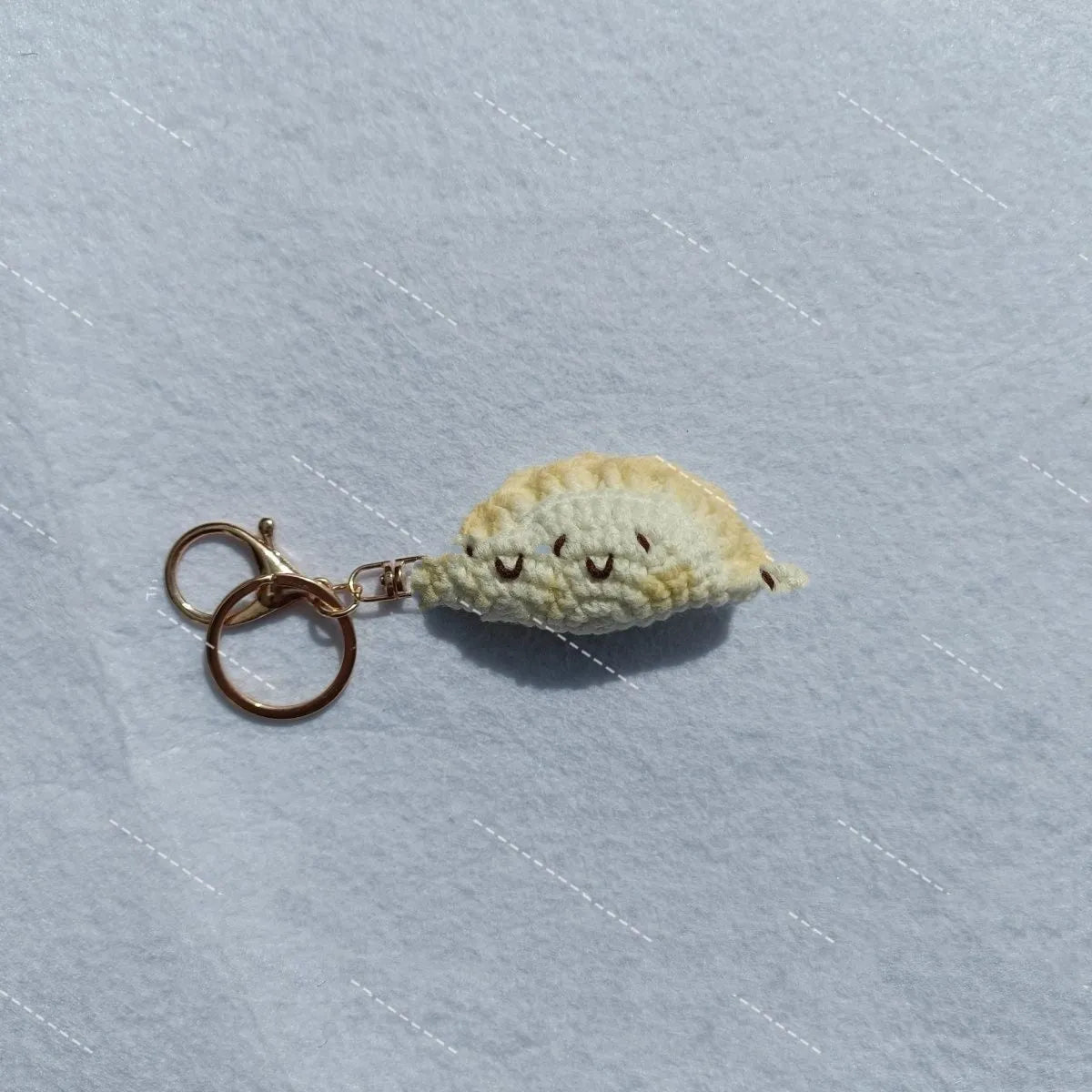 Handmade crochet dumpling pendant with keychain showing plush texture and hand-stitched decorative eyes