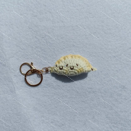 Handmade crochet dumpling pendant with keychain showing plush texture and hand-stitched decorative eyes
