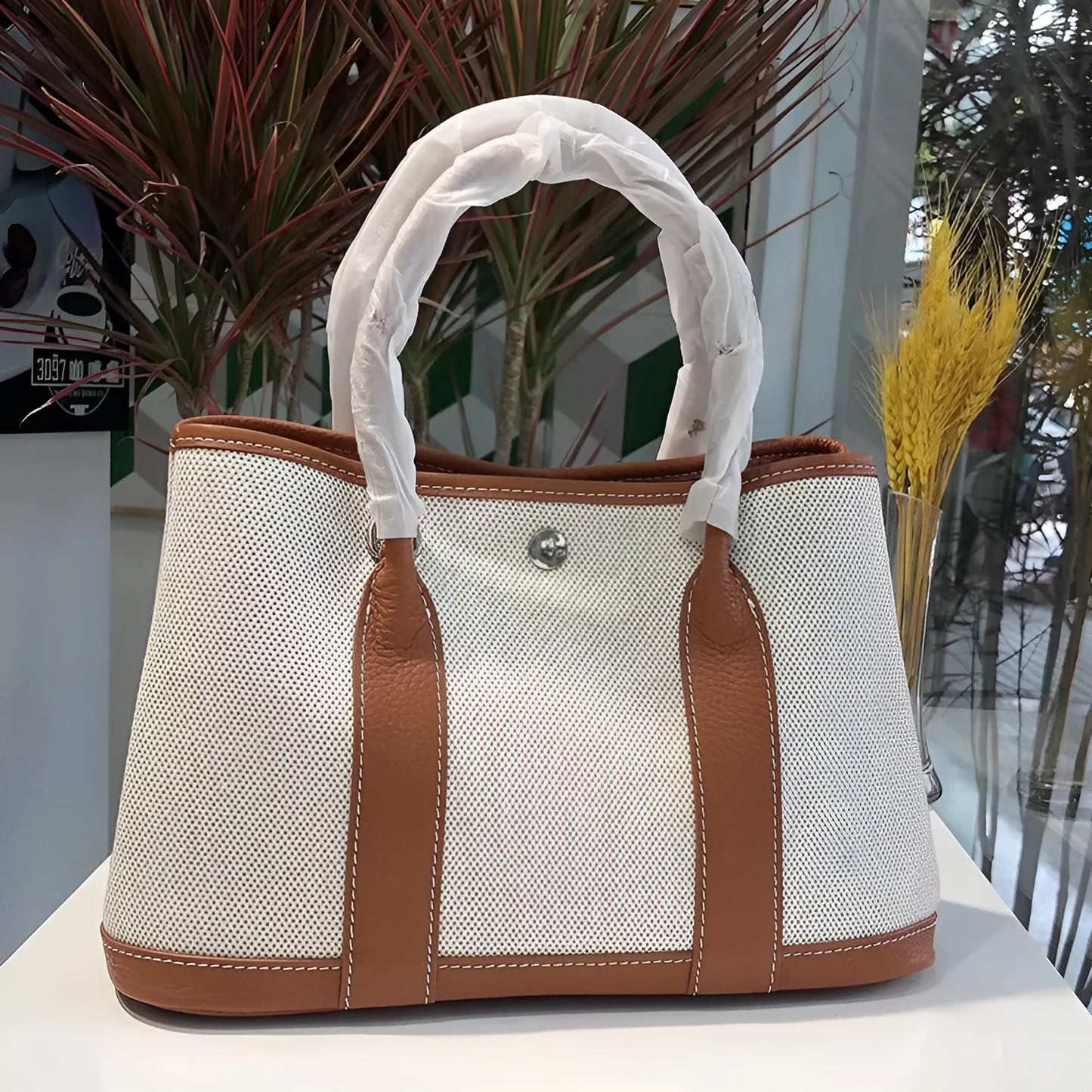 Genuine leather and canvas women's tote bucket bag in black, shown with a soft carry handle.