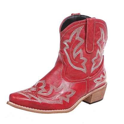 Women's blue embroidered cowboy boots with a low wedge heel and pointed toe on a wooden floor.