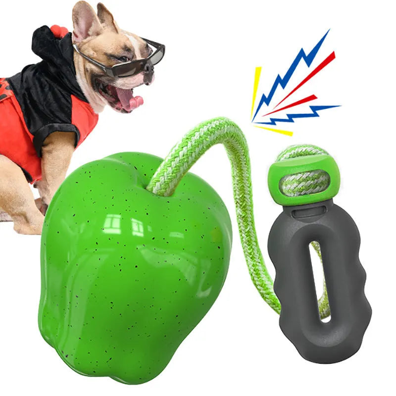 Green durable plastic dog toy shaped like a molar with a treat slot, on grass.