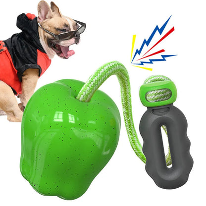 Green and red apple-shaped plastic dog toy with textured surface and a treat hole for interactive chewing.