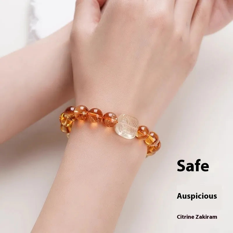 Close-up of a women's carved citrine bracelet with geometric patterns on 10mm crystal beads.