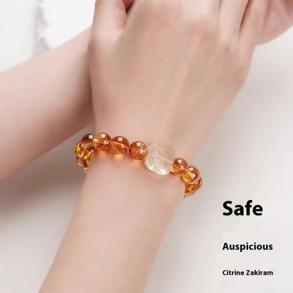 Close-up of a women's carved citrine bracelet with geometric patterns on 10mm crystal beads.