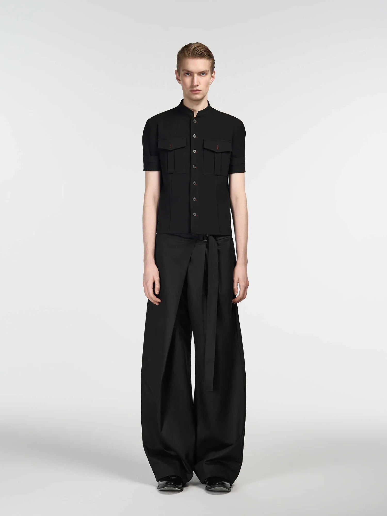 Black straight-leg trousers with a single front pleat and adjustable mid-waist on a hanger.