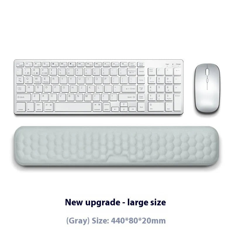 Black and grey memory foam mouse wrist rests with cloth and leather-style covers on a desk.