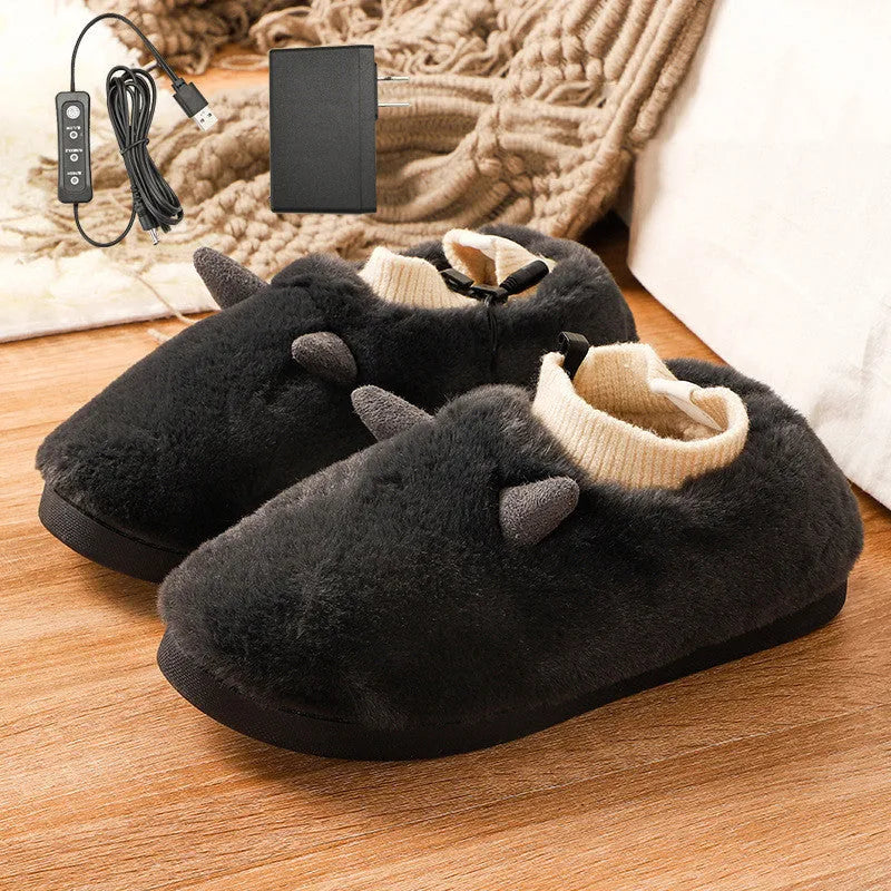 USB heated slippers in grey with a USB cable plugged into a power bank, showing the enclosed velvet design.