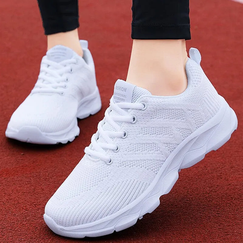 Women's white mesh fabric lace-up leisure shoes with a low heel on a plain background.