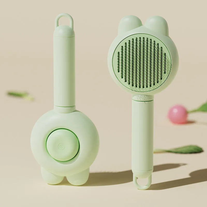Green self-cleaning pet grooming brush with a release button and rubber-tipped metal pins on a non-slip handle.