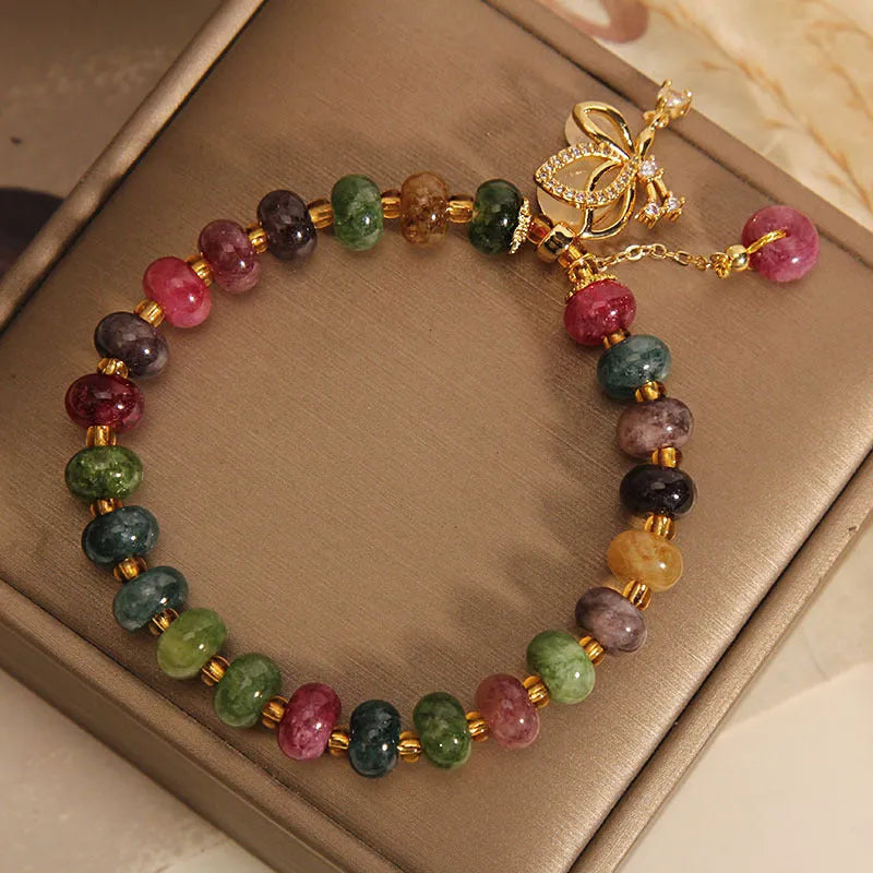 Colourful women's bracelet with butterfly charm, beads, and tourmaline accents on an alloy chain.