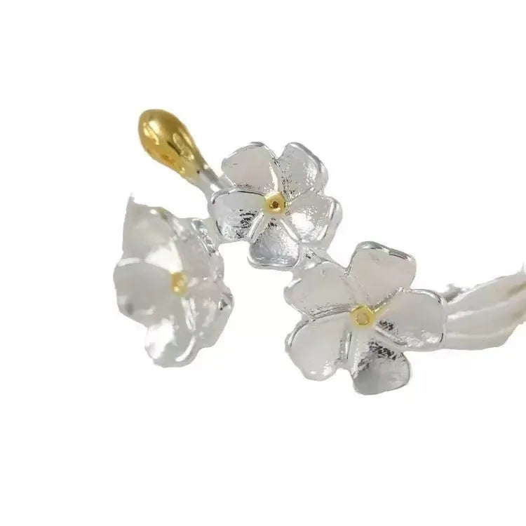 Adjustable three-dimensional jasmine flower ring in zinc alloy with electroplated finish on a hand.