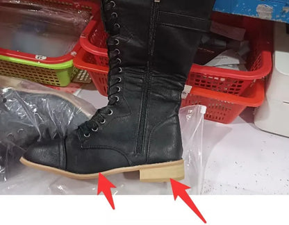 Women's black knight ankle boots with a cross strap fastening detail.