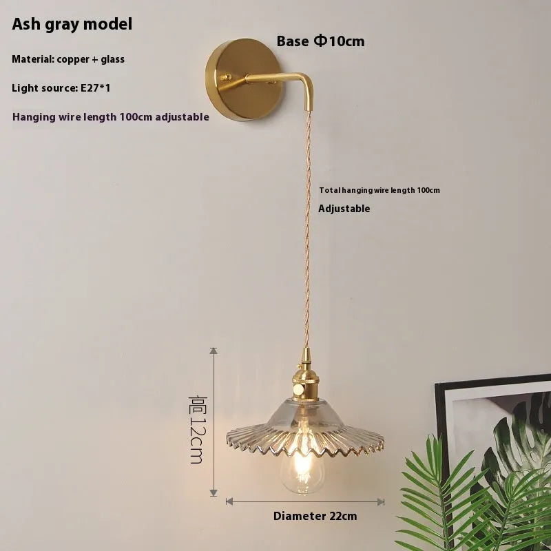 Retro brass lotus wall lamp with copper body and glass shade in various colours, mounted on a wall
