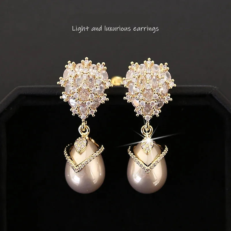 Women's drop-shaped freshwater pearl earrings with zircon inlay on 18K gold-plated settings.