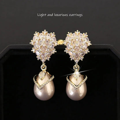 Women's drop-shaped freshwater pearl earrings with zircon inlay on 18K gold-plated settings.